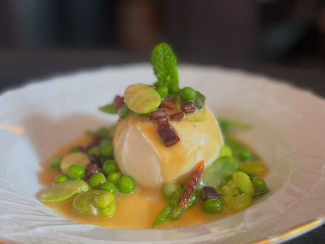 A round of burrata with peas, broad beans and pancetta in a butter sauce.