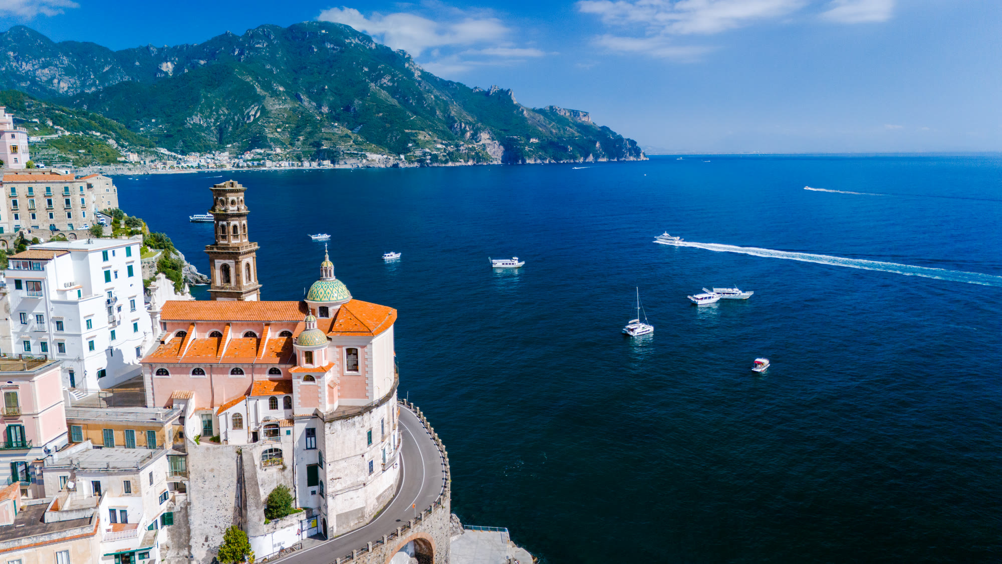Pastel houses stacked above the sea on an Italian coastline.
